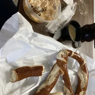 Biggest pretzel I have ever seen served with mustard and crab dip. she had eaten most of pretzel