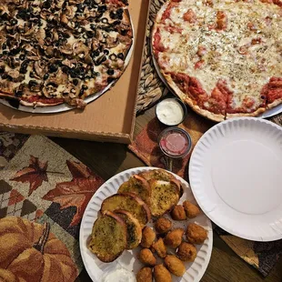 two pizzas and a plate of fried potatoes