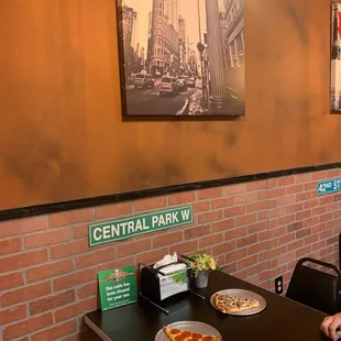 a man sitting at a table with a plate of pizza