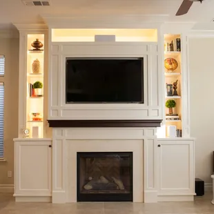 a living room with a fireplace and entertainment center