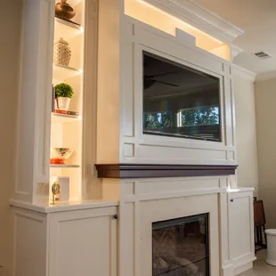 a living room with a fireplace and entertainment center