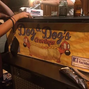 a woman reaching for a hot dog