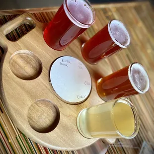 a wooden tray with beer glasses on it