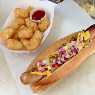 a hot dog with mustard, onions, and ketchup