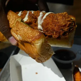 a hand holding a fried chicken sandwich