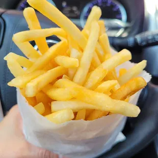 a person holding a basket of french fries