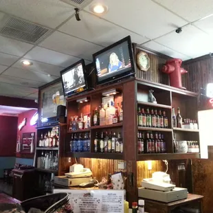 a bar with a television and shelves of liquor