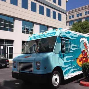 a blue food truck parked in front of a building