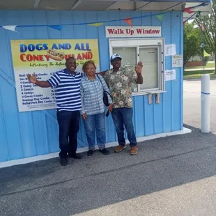 three people standing in front of a dog and all cone island