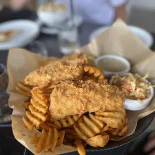 Three amazing pieces of fish on a huge mound of wonderfully made waffle fries.