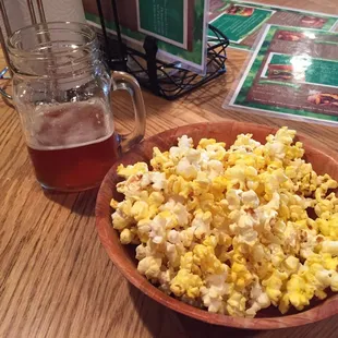 a bowl of popcorn and a glass of beer