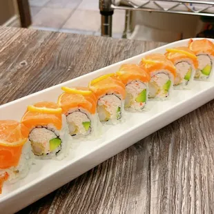 a long white plate with sushi on it