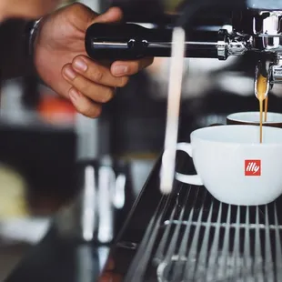 a person pouring a cup of coffee