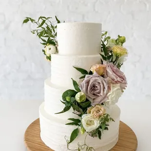 Custom four tier wedding cake with fresh florals giving us all the heart eyes.