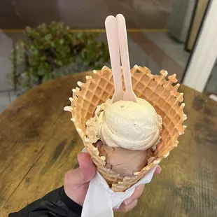 a hand holding a cone of ice cream
