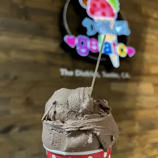 a hand holding a cup of ice cream