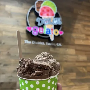 a hand holding a cup of ice cream