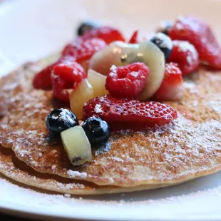 a stack of pancakes topped with fruit