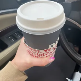 a hand holding a coffee cup