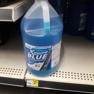 a bottle of blue liquid on a shelf