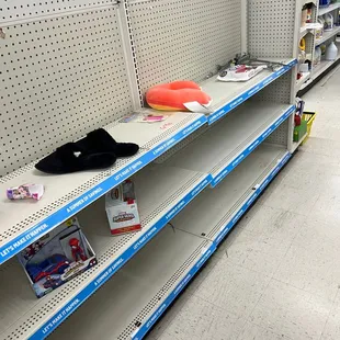Empty messy shelves while other shelves close by overflowing