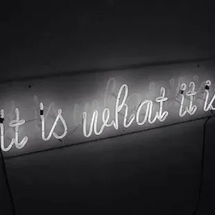 a neon sign that says it is what it is