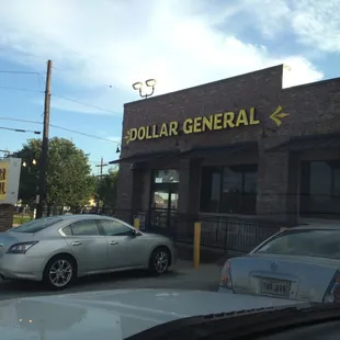 cars parked in front of a dollar general store
