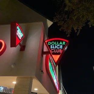 a neon sign for the dollar slice club