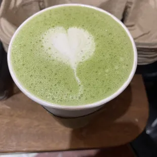 a cup of matcha with a heart drawn in it