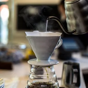 a person pouring a cup of coffee