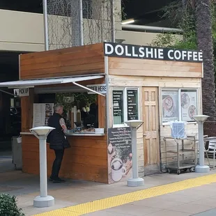 a woman standing in front of a coffee shop