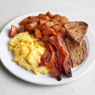 a plate of eggs, bacon and toast