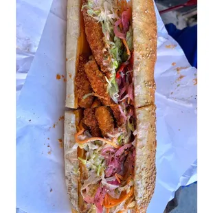 a sub sandwich with meat, coleslaw, and slaw