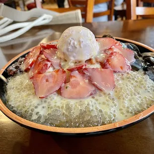 a bowl of ice cream and strawberries