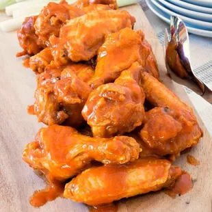 a pile of wings on a cutting board