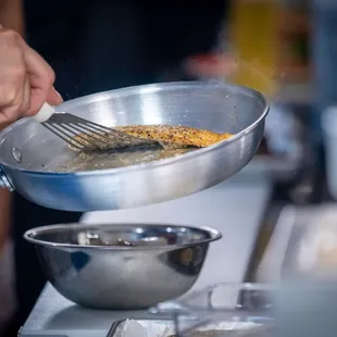 a person stirring food in a pan