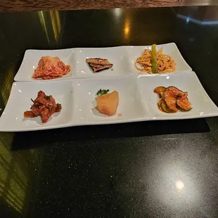 Banchan - small side dishes often includes kimchi, spicy marinated cucumber, marinated bean sprouts....