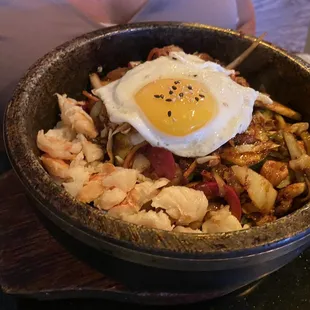 a bowl of food with a fried egg on top