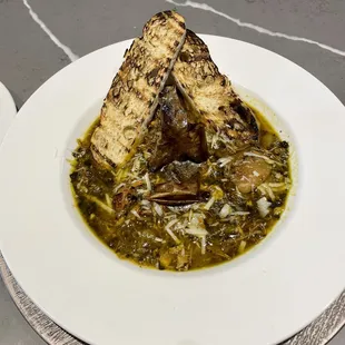 a bowl of soup with toasted bread