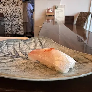 a piece of fish on a plate with a fork
