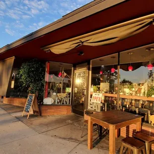 the outside of a restaurant with tables and chairs
