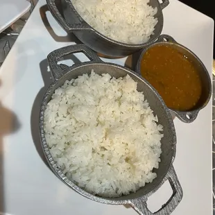 a plate of white rice and two bowls of curry