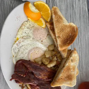 bacon, eggs, toast, and orange slices