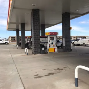 a gas station with a gas pump in the foreground