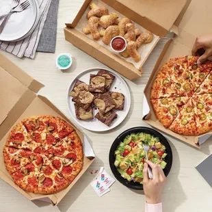 a table with pizzas and other food items