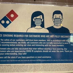 a sign stating customers to wear face masks