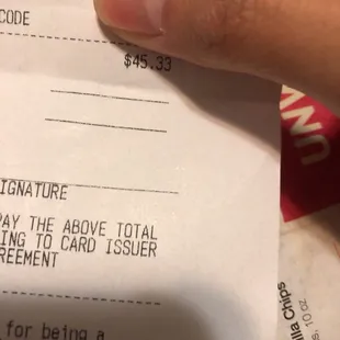 a hand holding a receipt