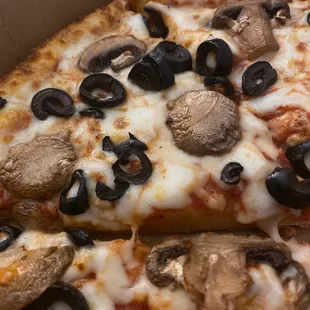 a pizza with mushrooms and black olives
