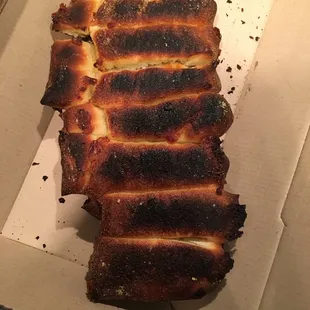 a piece of burnt pizza in a box