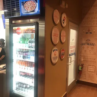 a pizza shop with pizzas on the wall